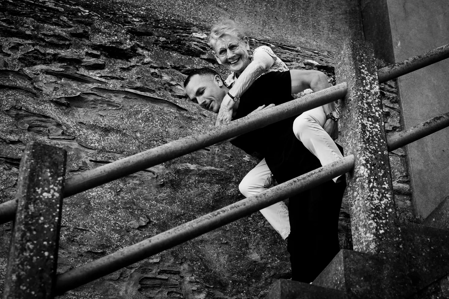 reportage photo à pornic. sur cette photo le petit fils portage sa grand mère sur le dos, pour rejoindre la plage
