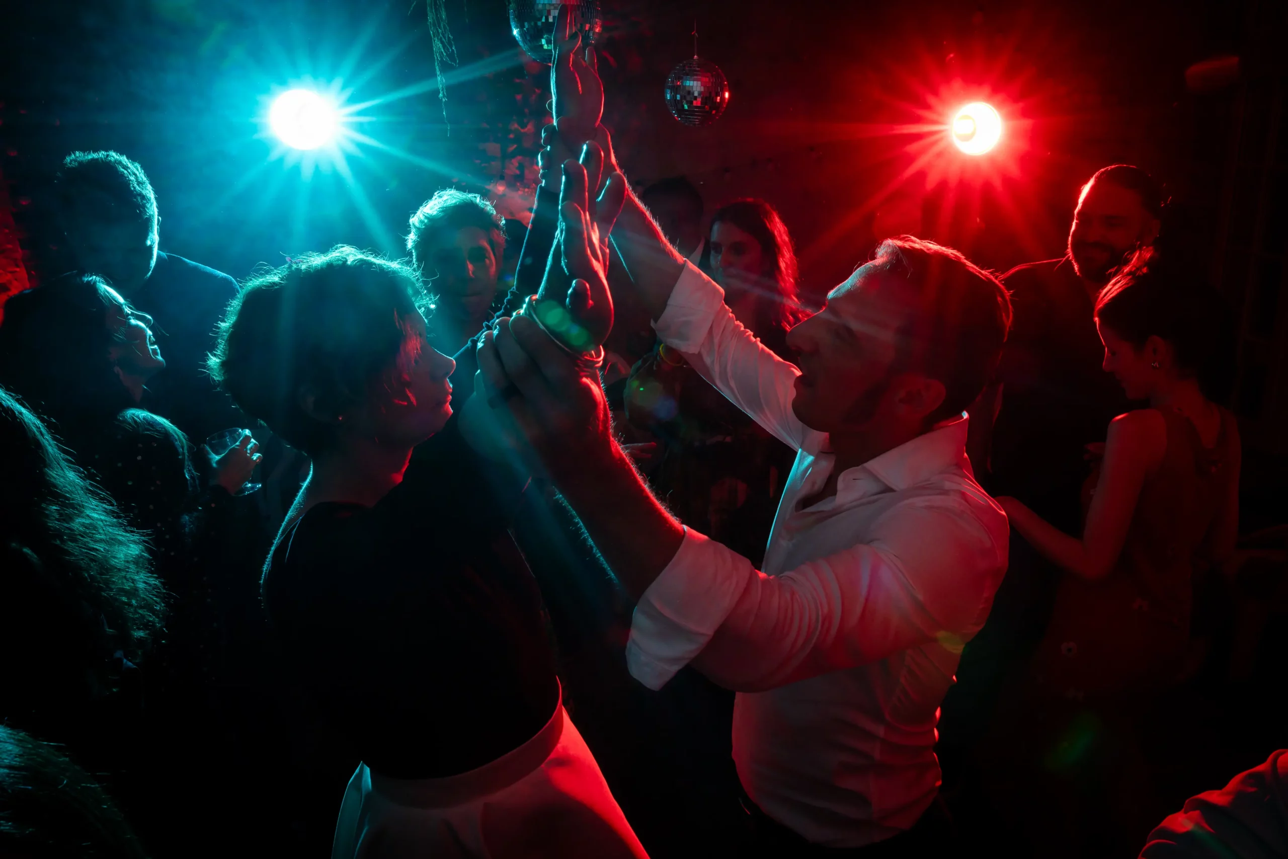 reportage mariage pendant la soirée, utilisation de flashs bleu et rouge, en premier plan les mariés