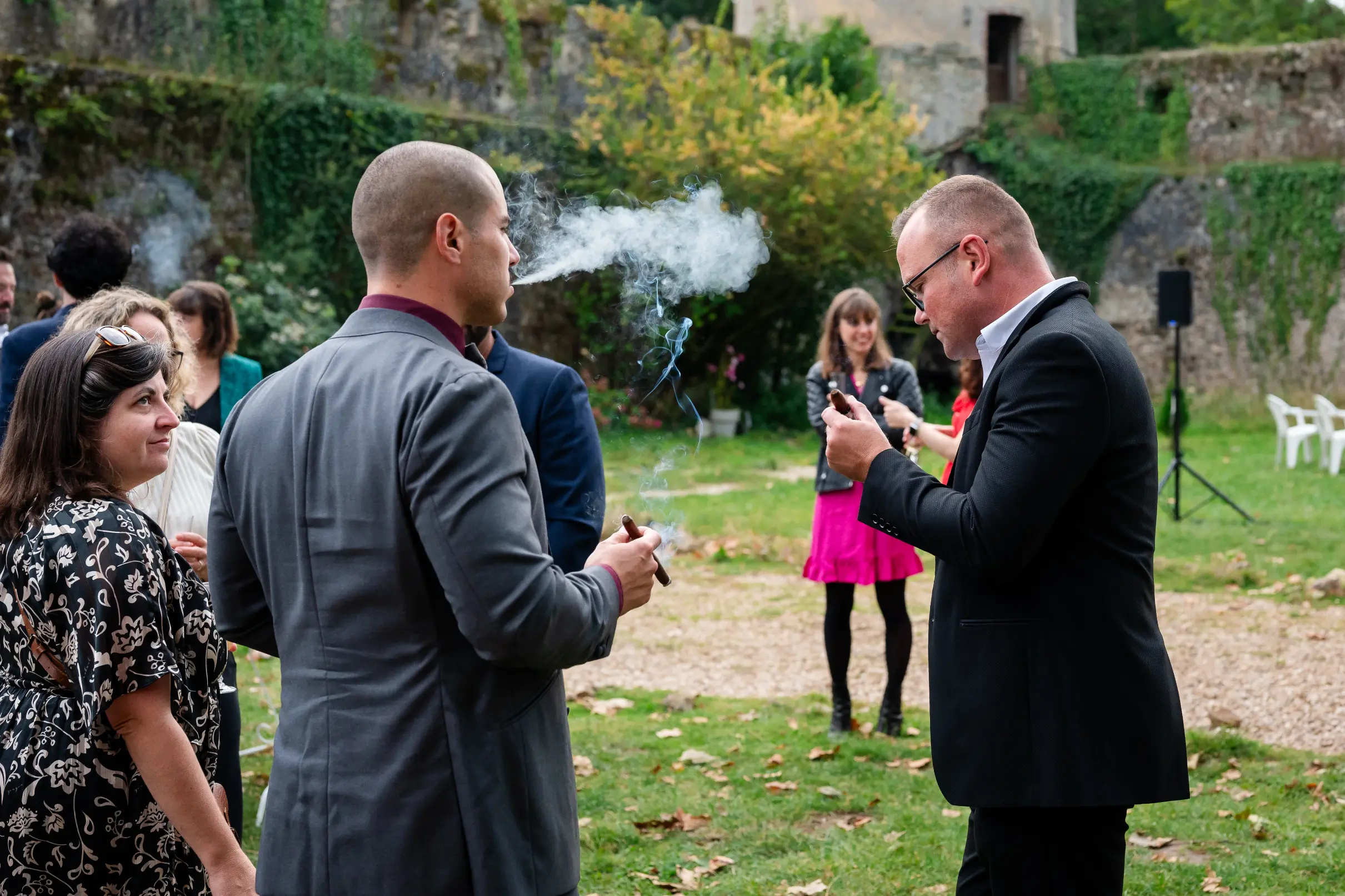 photographe-mariage-loire-atlantique-cocktail photographie lors d'un cocktail d'un mariage d'un château de loire atlantique, On voit deux invités qui fument un cigare