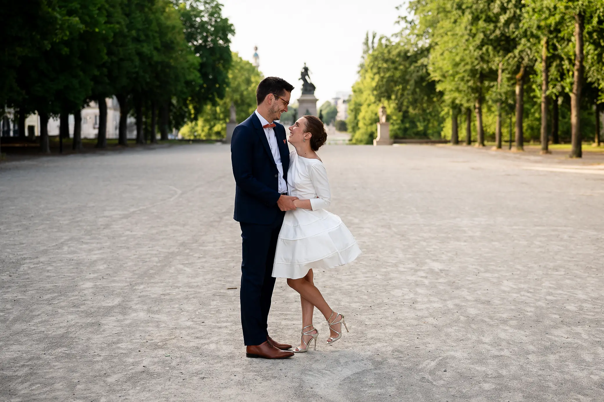 photographe-mariage-nantes-cour-saint-andre reportage photograhique de mariage prise à Nantes, cour saint André. photo prise lors d'une séance couple day after, au petit matin. les deuxmariés se font face en souriant, et en arrière plan on voit la tour Lu.
