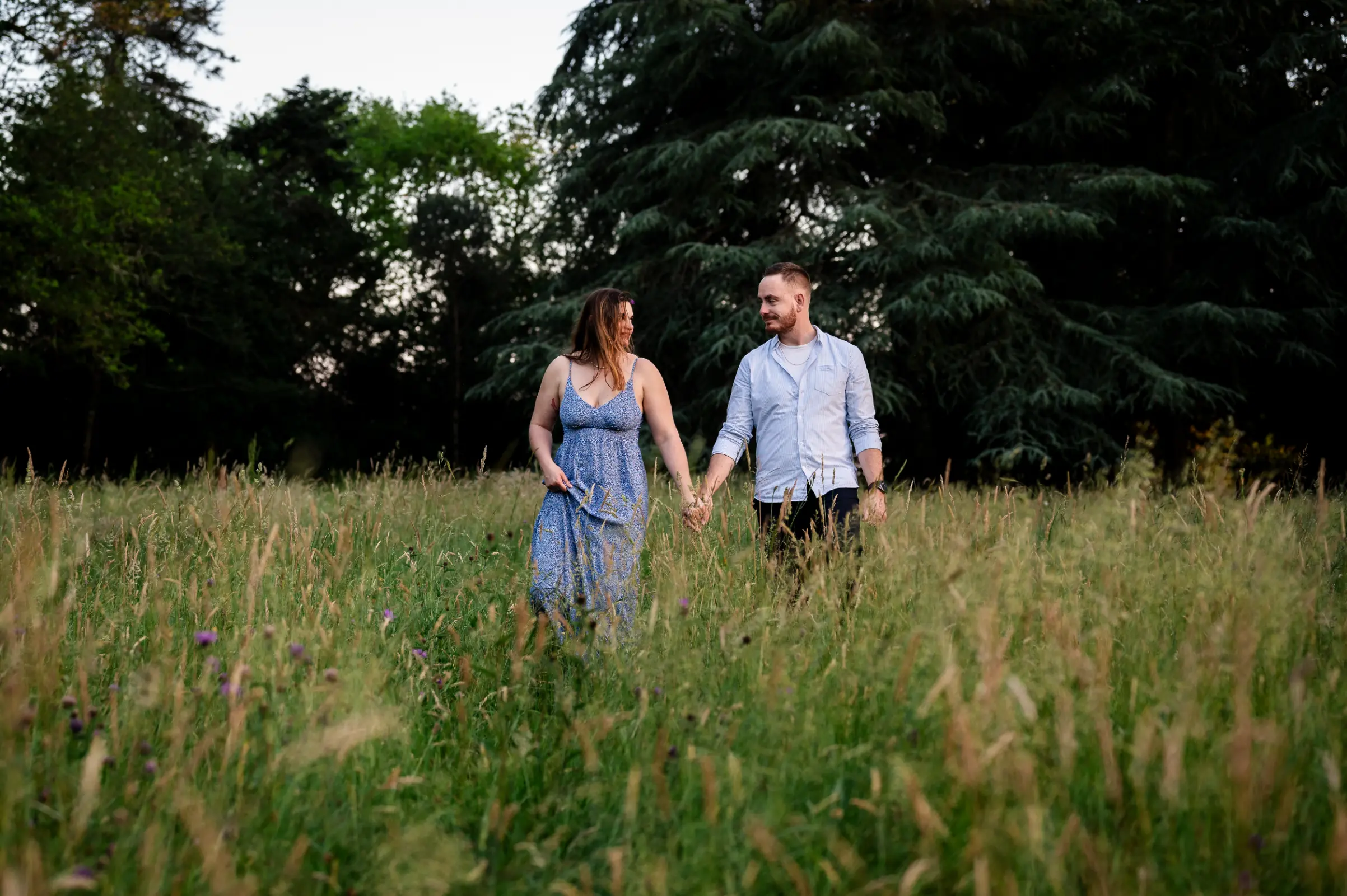photo-reportage-photo un couple de futurs mariés, profite de cette séance couple pour appréhender l'appareil photo, la scène se passe dans les hautes herbes, en fin de journée au parc de la chantrerie, sous un lumière orangée