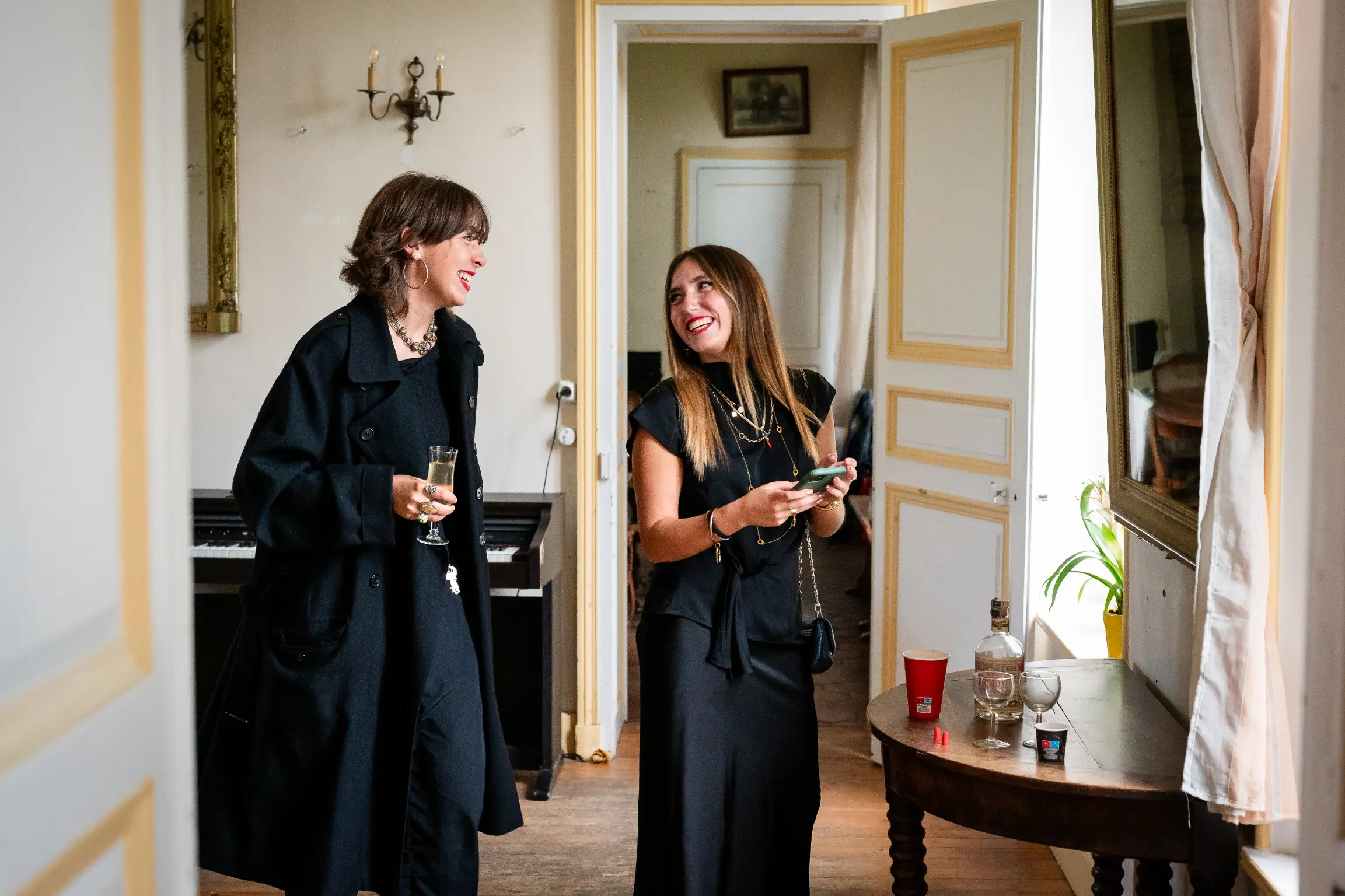 choisir-votre-photographe-invitees-amusees lors des préparatif s d'un mariage, la mariée et sa témoin rigolent pendant qu'elle se font coiffée, approche du photojournalisme du mariage