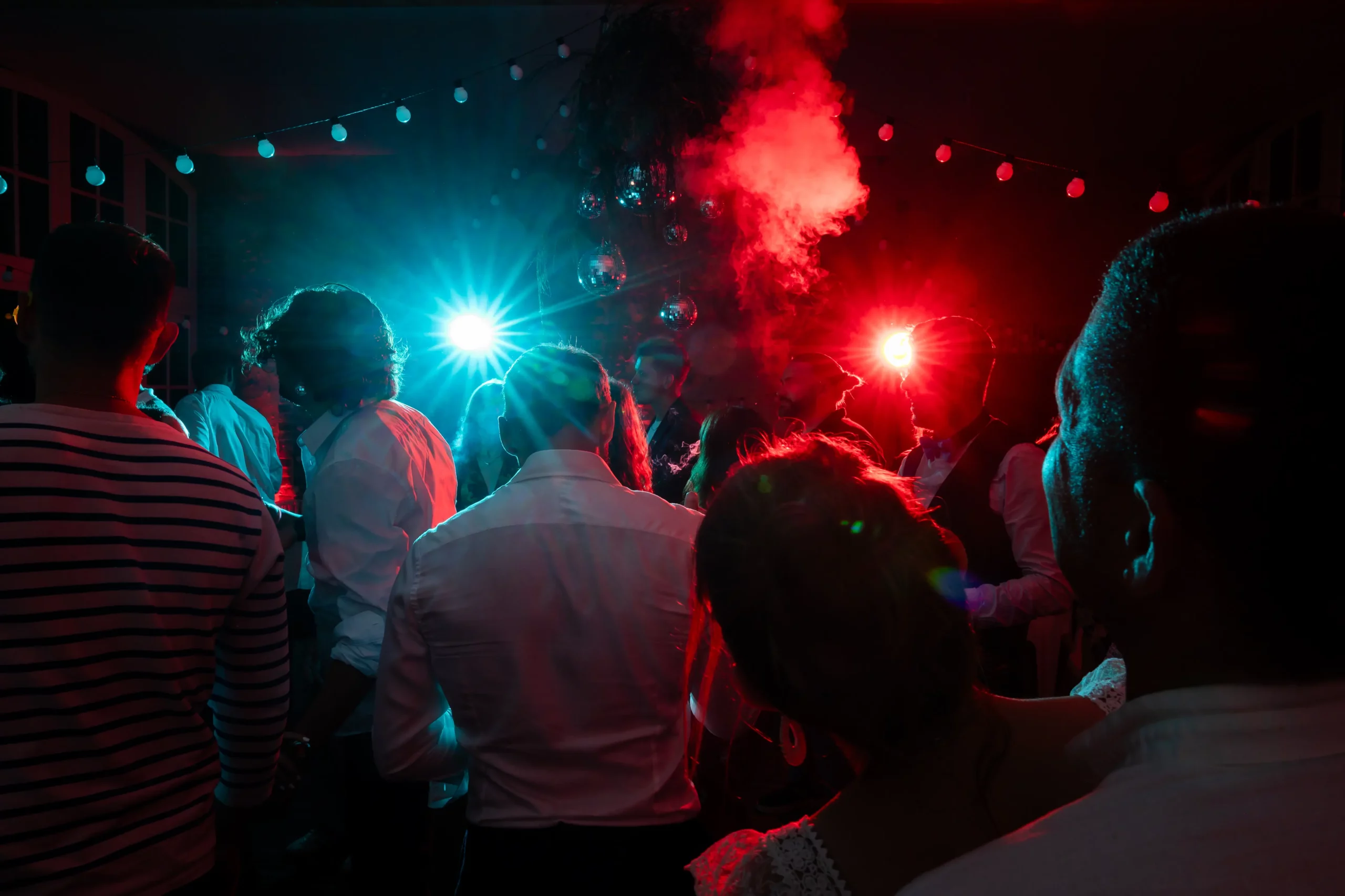 mariage-photojournalisme-soiree-flashs image prise lors d'une soirée d'un mariage, l'invitée fument avec en arrière plan les flashs du photographe kévin marzin