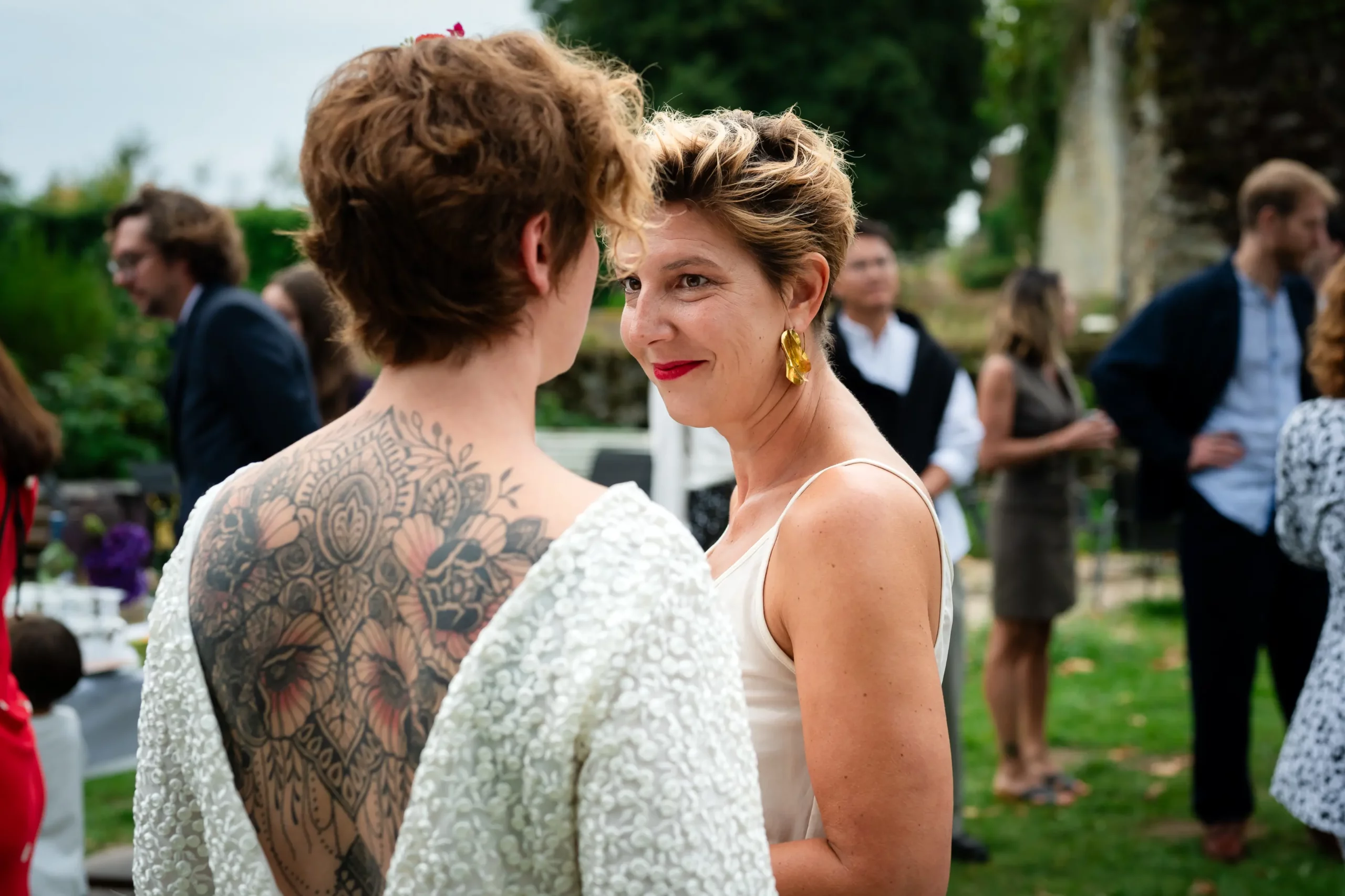 la mariée embrasse son époux à la fin de la cérémonie laïque du mariage, en arrière plan les invités applaudissent